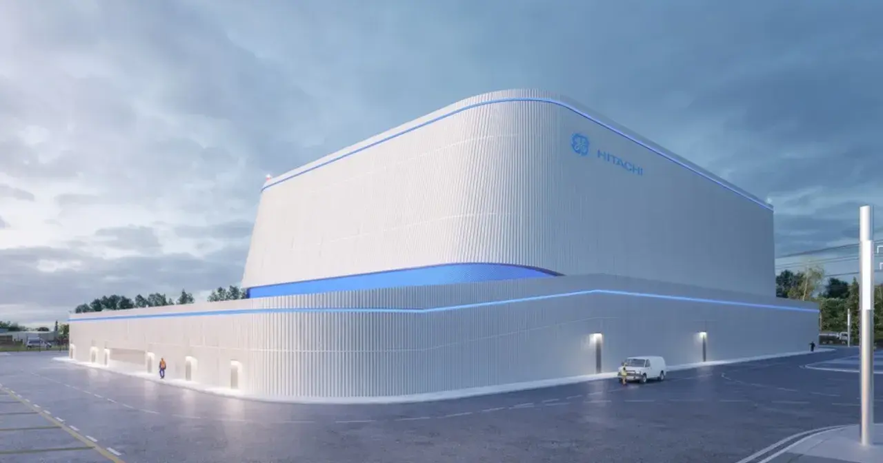 Nowoczesny budynek z logo GE Hitachi, prawdopodobnie elektrownia jądrowa BWRX-300, z niebieskimi akcentami świetlnymi.